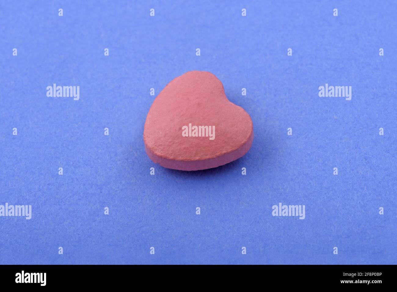 Forma del corazón tableta de medicina farmacéutica sobre fondo azul, Lay plano Copiar espacio conceptos de medicina Color azul claro fondo Foto de stock