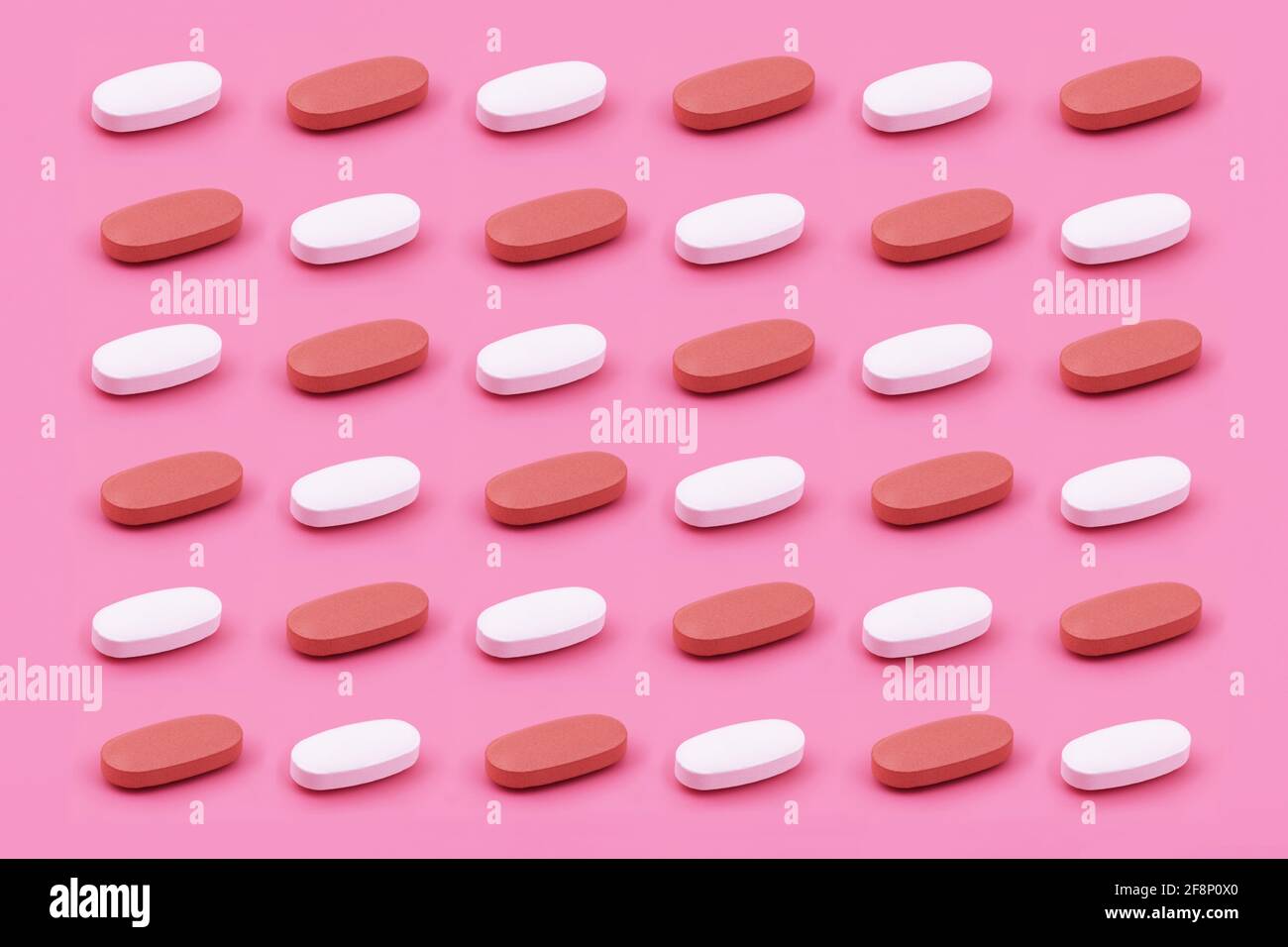 Forma ovalada tableta de medicina farmacéutica sobre fondo rosa, Medicina conceptos creativos estilo mínimo con fondo de papel colorido Foto de stock