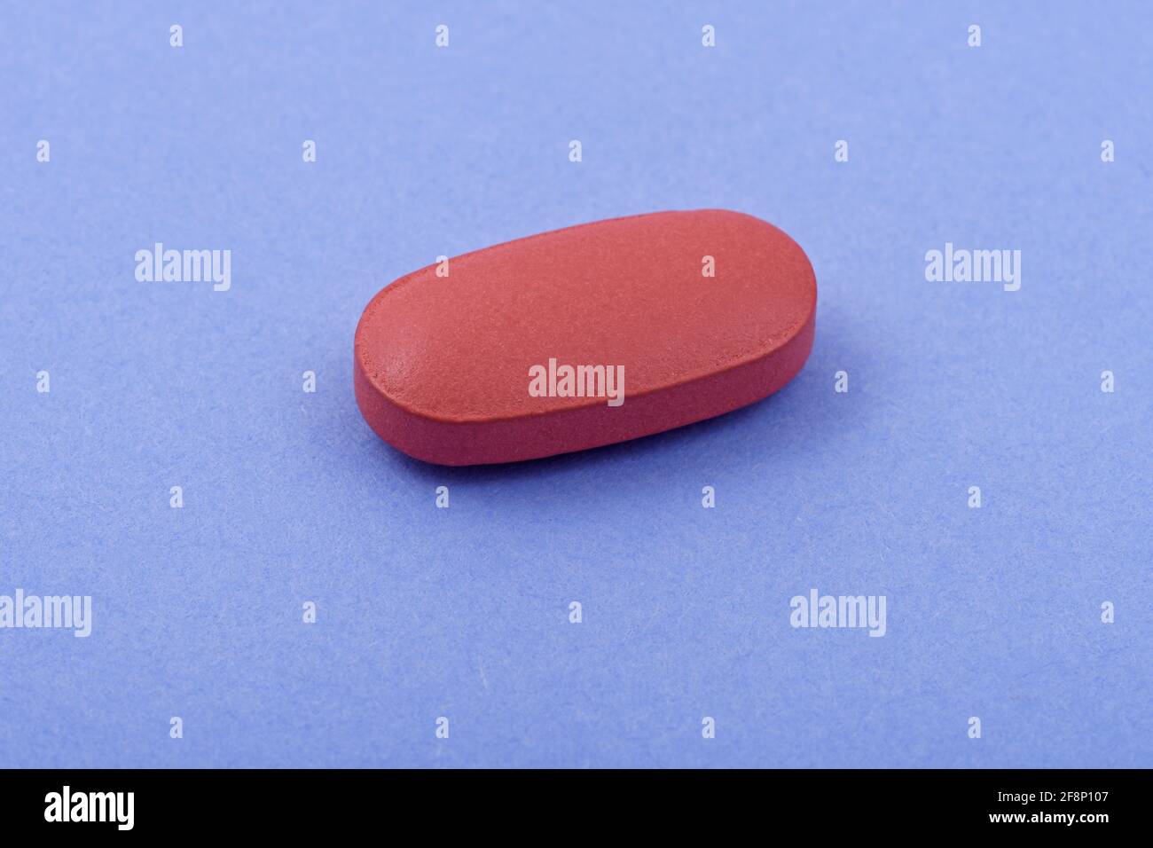 Forma ovalada tableta de medicina farmacéutica sobre fondo azul, Lay plano espacio de copia conceptos de medicina Color azul claro fondo Foto de stock