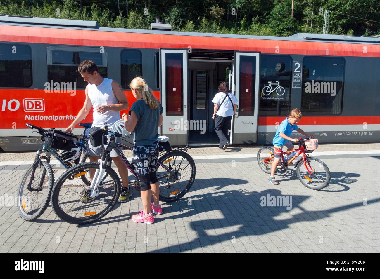 Familia con bicicleta viajando en tren regional, hombre mujer niño Sajonia Alemania ferrocarril Foto de stock