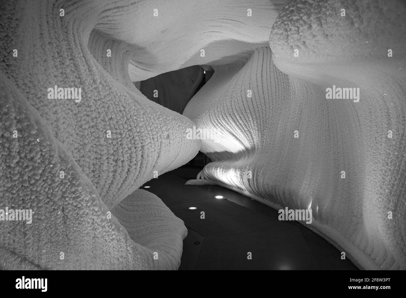 Una fabulosa cueva de hielo artificial, las paredes están cubiertas de nieve e iluminadas. Hielo congelado y frío en el interior Foto de stock