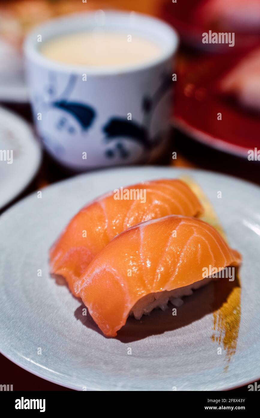 Sushi y sashimi. Platos de Sushi y Sashimi rodando sobre cinta transportadora. Foto de stock