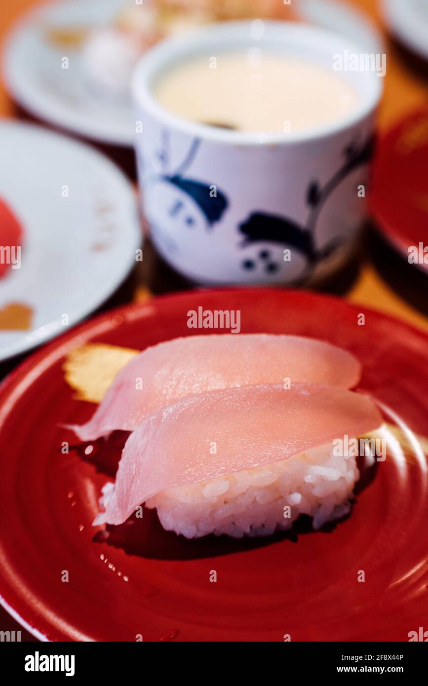 Sushi y sashimi. Platos de Sushi y Sashimi rodando sobre cinta transportadora. Foto de stock