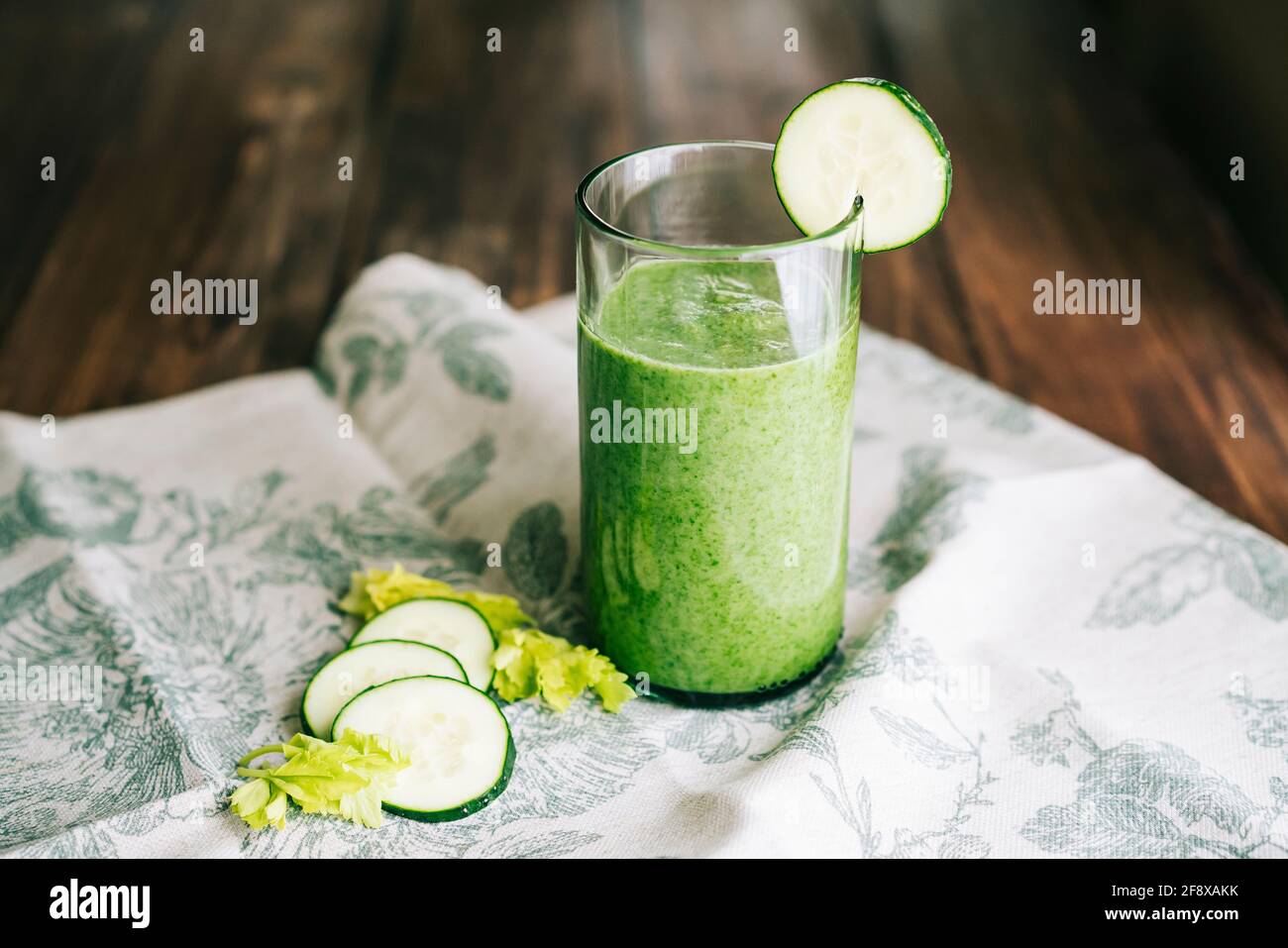 Batido verde con apio y pepino en cristal un paño gris de hojas verdes  sobre una madera oscura tabla Fotografía de stock - Alamy