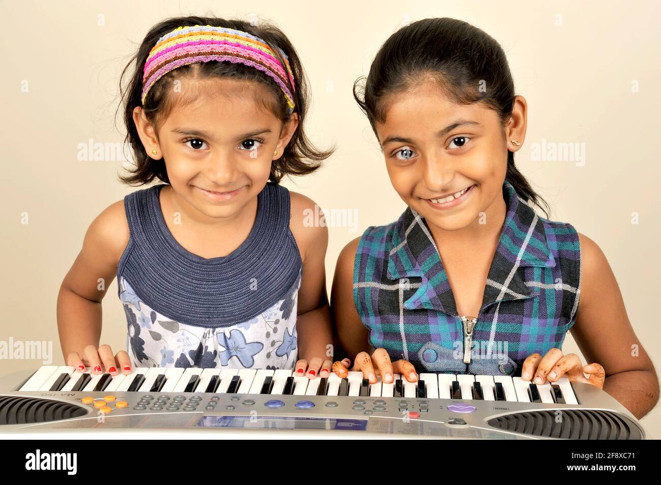 Mumbai, Maharashtra, India- Asia; 02 de noviembre de 2011 -Dos chicas pequeñas tocando Piano Multifunción Teclado de Música Electrónica de Órgano de 37 teclas. Foto de stock