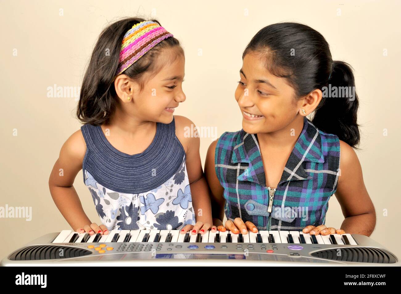 Mumbai, Maharashtra, India- Asia; 02 de noviembre de 2011 -Dos chicas pequeñas tocando Piano Multifunción Teclado de Música Electrónica de Órgano de 37 teclas. Foto de stock