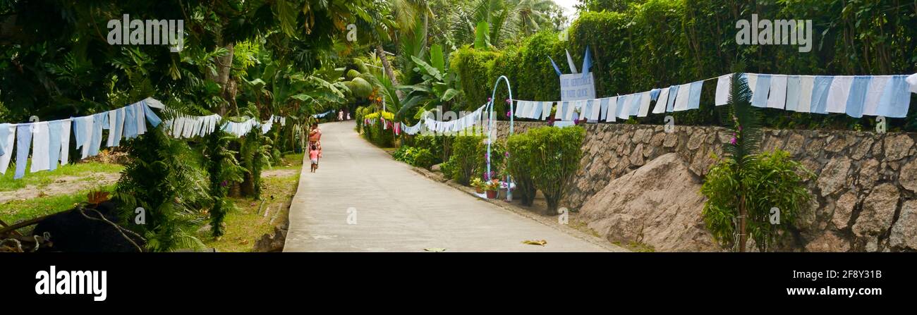 Banderas de tela al borde de la carretera para la celebración del Día de la Asunción, Seychelles Foto de stock