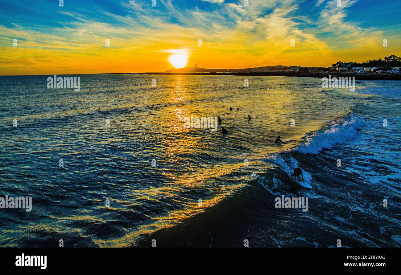 Vista aérea de surfistas en el mar al atardecer, Half Moon Bay, California, Estados Unidos Foto de stock