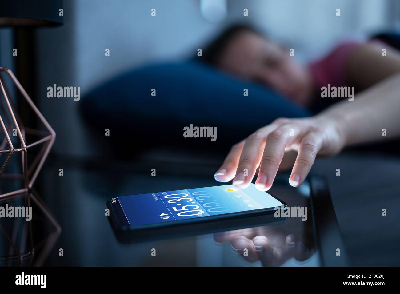 Alarma Desactivación del despertador en el teléfono móvil femenino  Fotografía de stock - Alamy