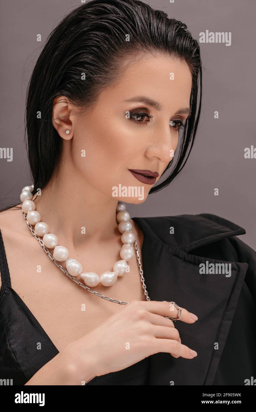 Retrato de una mujer hermosa que lleva un collar de perlas Foto de stock