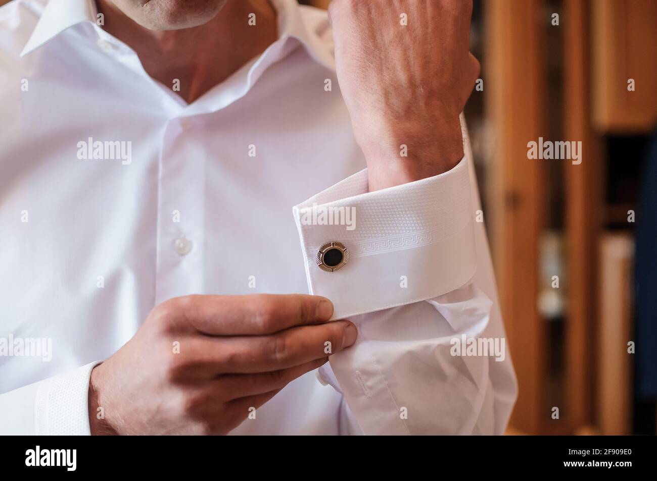 El hombre fastens el gemelos en la manga de su camisa. El novio sujeta un  botón en la manga de su camisa Fotografía de stock - Alamy