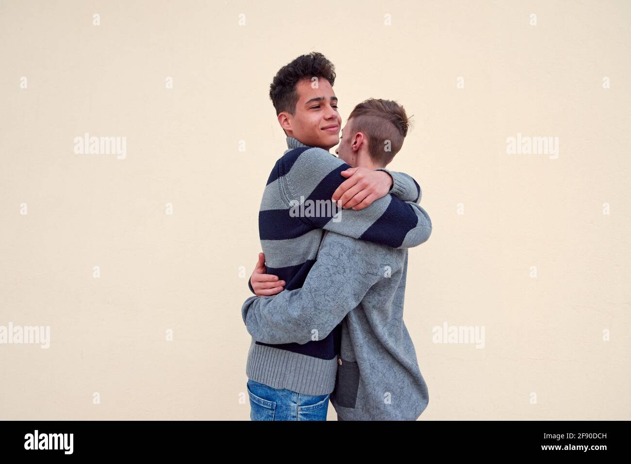 Joven pareja gay interracial abrazando aislado sobre un fondo beige  Fotografía de stock - Alamy