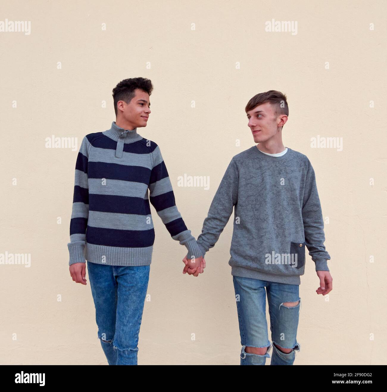 Joven pareja gay interracial con las manos aisladas en un beige  antecedentes Fotografía de stock - Alamy