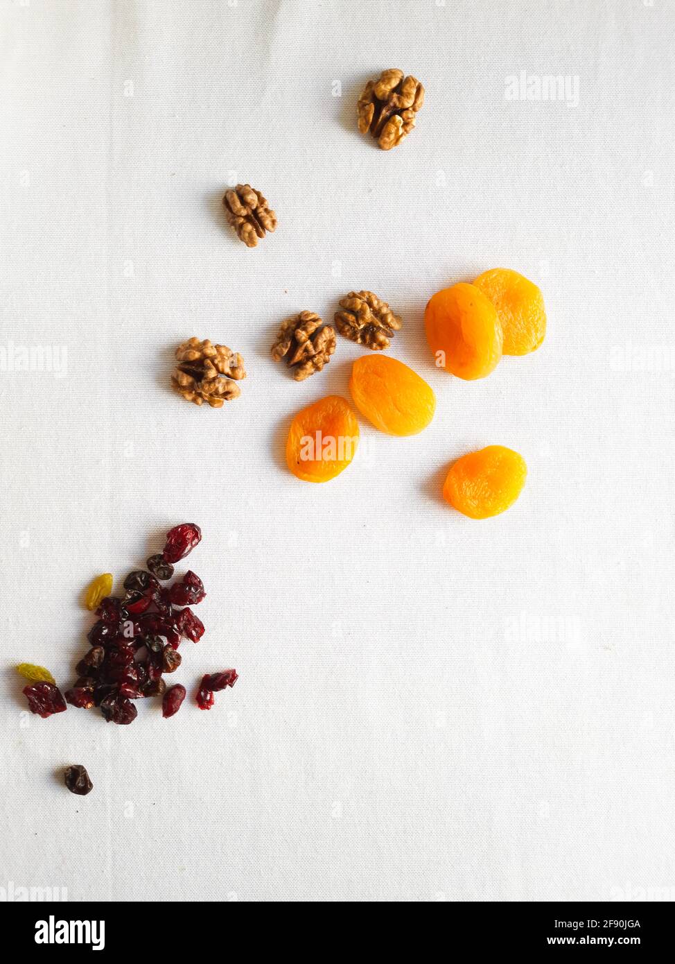 Nueces, pasas, arándanos secos y albaricoques secos sobre mesa blanca Foto de stock