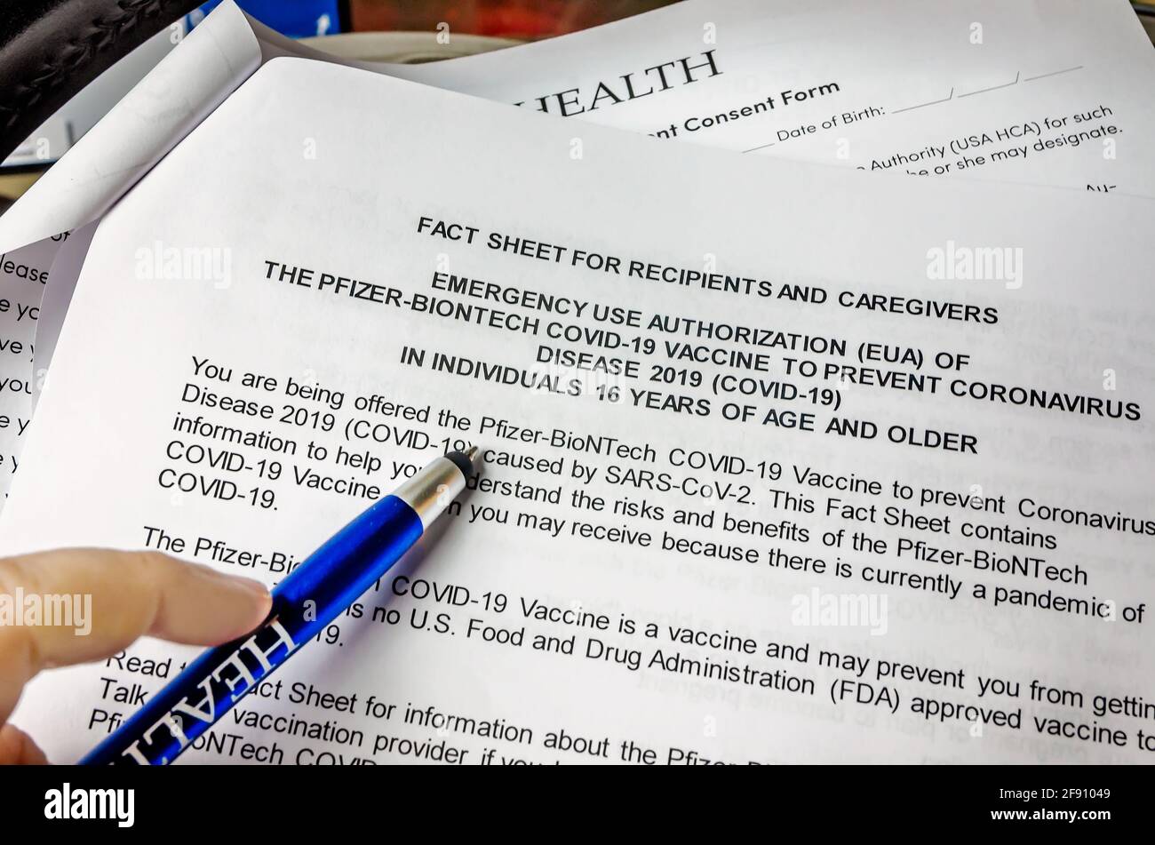 Un paciente lee un formulario de consentimiento antes de recibir la primera dosis de la vacuna COVID-19 por Pfizer-BioNTech en el Mobile Civic Center en Mobile, Alabama. Foto de stock