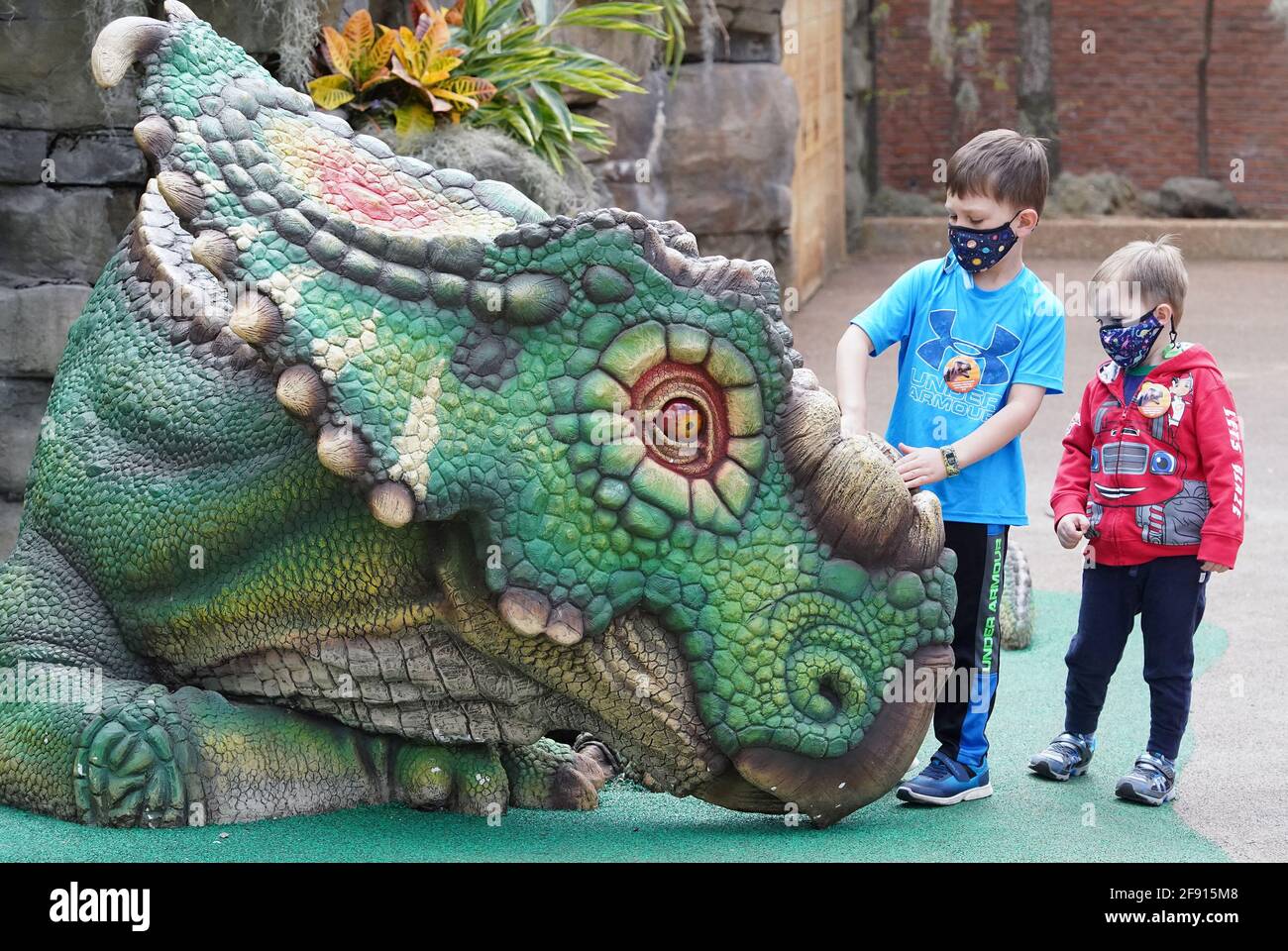 St. Louis, Estados Unidos. 15th de Abr de 2021. Boone (6) y Gates (4) Grimshaw, eche un vistazo más de cerca a la colorida exhibición de Pachyrhinosaurus en el zoológico de Saint Louis el jueves, 15 de abril de 2021. La nueva atracción cuenta con 16 grupos diferentes de dinosaurios animatrónicos y estacionarios. Foto de Bill Greenblatt/UPI Crédito: UPI/Alamy Live News Foto de stock
