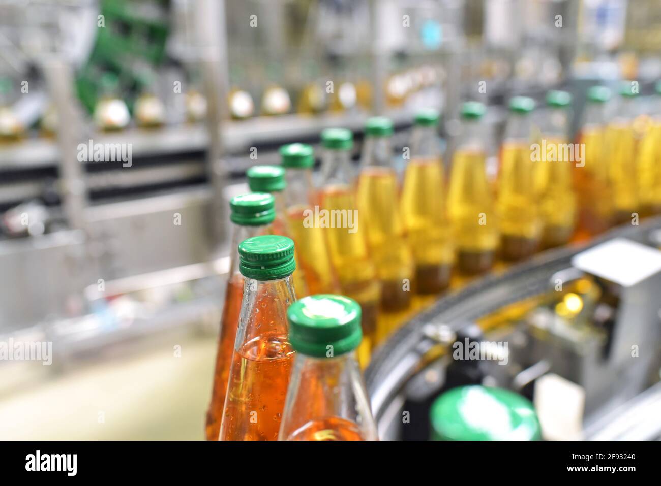 jugo de manzana en botellas de vidrio en una fábrica para la industria alimentaria - embotellado y transporte Foto de stock