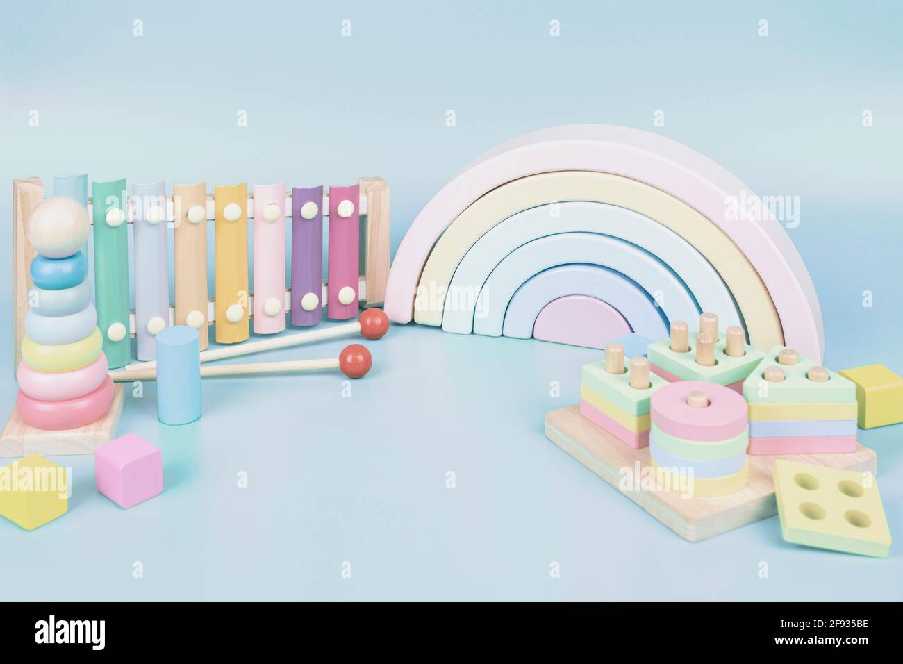 Colección de juguetes para niños. Arco iris de madera, educación y música  juguetes de bebé sobre fondo azul claro Fotografía de stock - Alamy