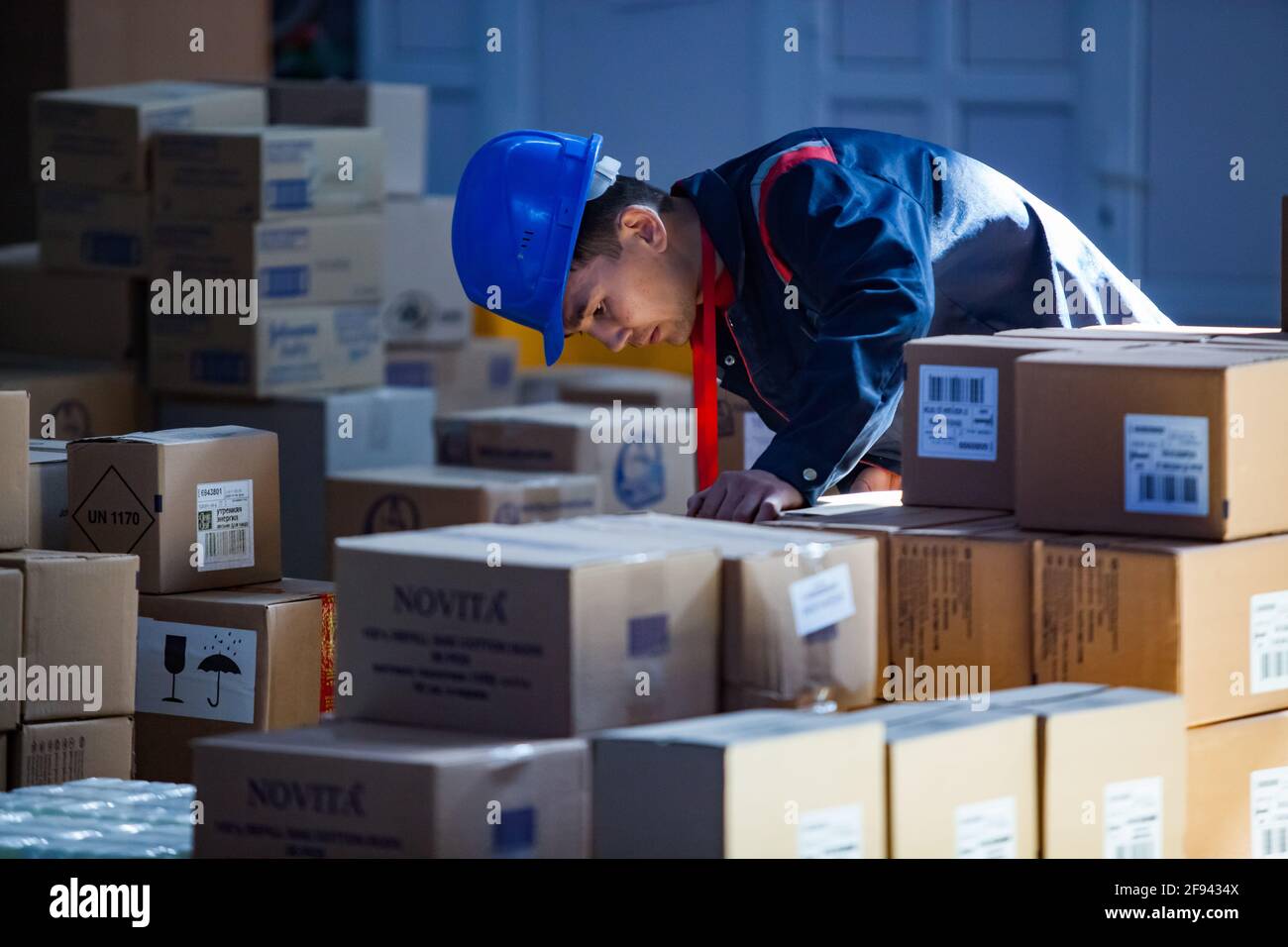 Moderno centro logístico y almacén. Operador asiático joven que comprueba  cajas de cartón. Aktobe, Kazajstán Fotografía de stock - Alamy