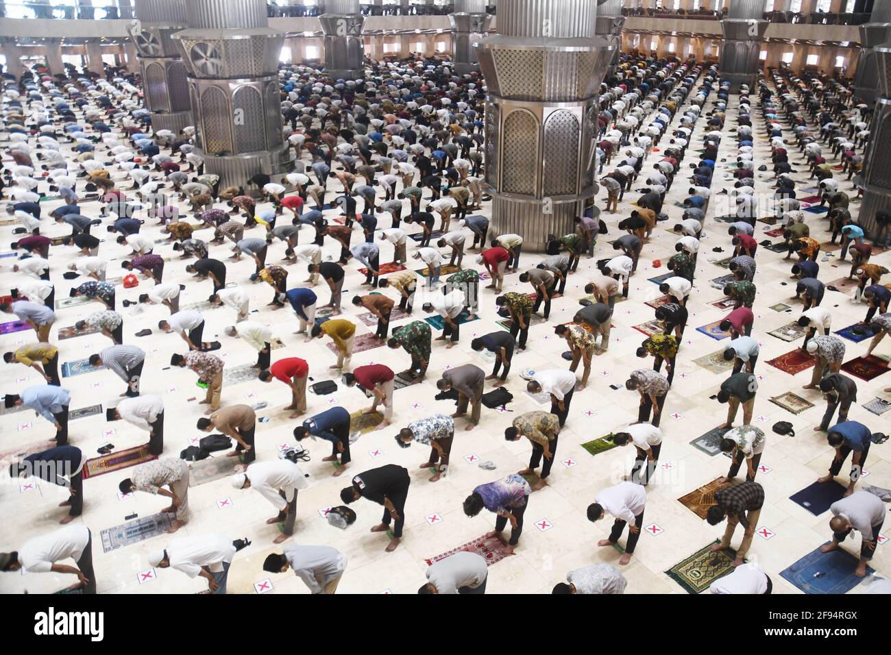 (210416) -- JAKARTA, 16 de abril de 2021 (Xinhua) -- Los musulmanes asisten a la oración del primer viernes al mediodía con distanciamiento social durante el mes santo del Ramadán en la Mezquita Istiqlal en Yakarta, Indonesia, el 16 de abril de 2021. (Foto: Dasril Roszandi/Xinhua) Foto de stock