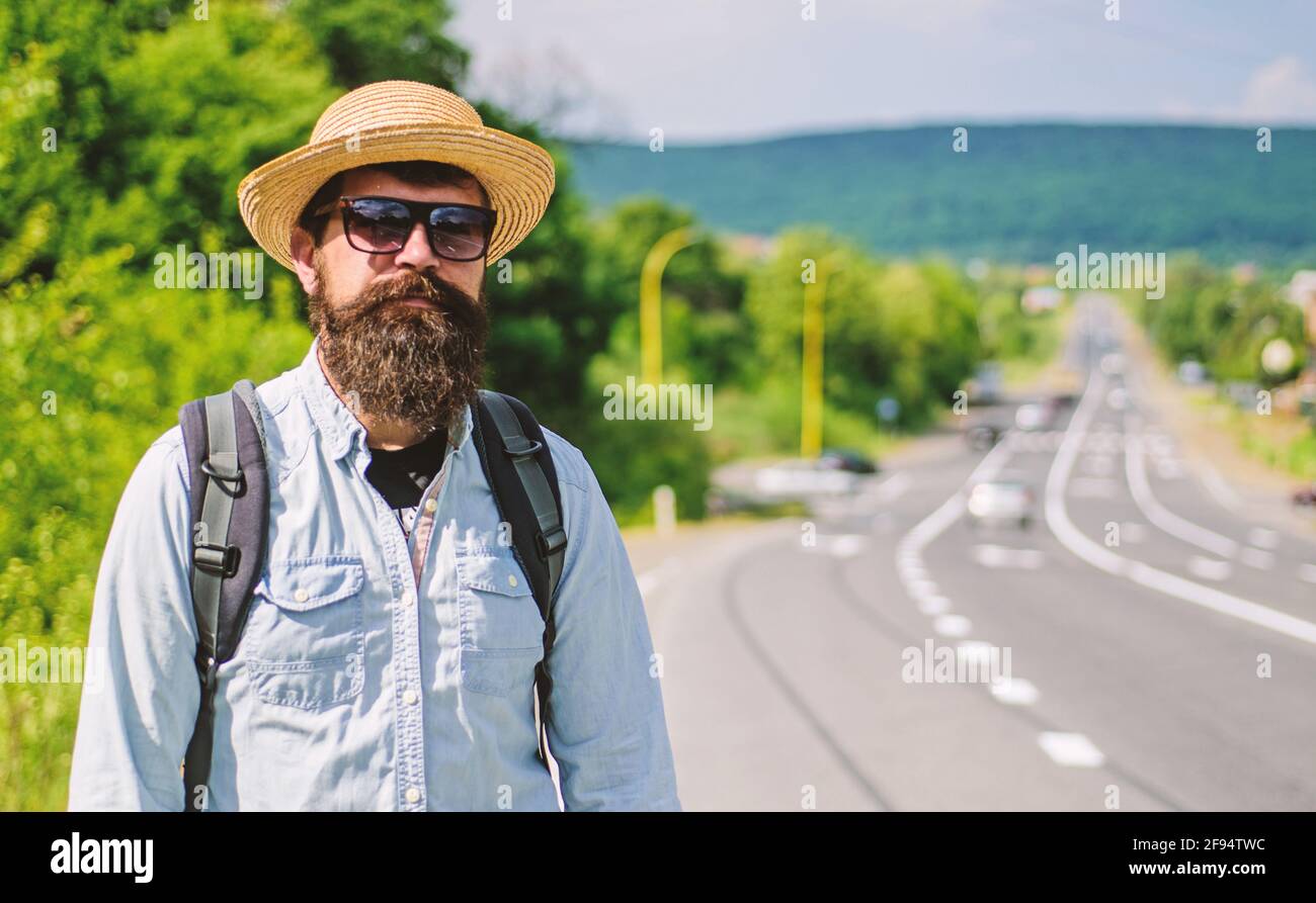 Hombre barbudo hipster mochilero en el borde de la autopista. Llévame  contigo. El viajero que espera el coche lo lleva de todos modos sólo para  caer en un mejor lugar. Busque Fotografía