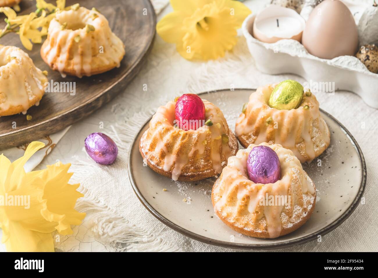 Deliciosas tortas caseras de bollitos de limón (magdalenas) y huevos de  chocolate en una mesa de pascua con flores frescas de primavera Fotografía  de stock - Alamy