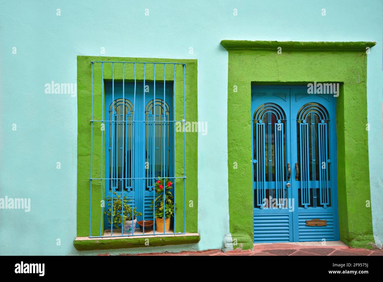 Casa colonial pared de estuco turquesa con una puerta y ventana con borde  verde lima y rejillas de hierro artesanales en Santiago de Querétaro, México  Fotografía de stock - Alamy