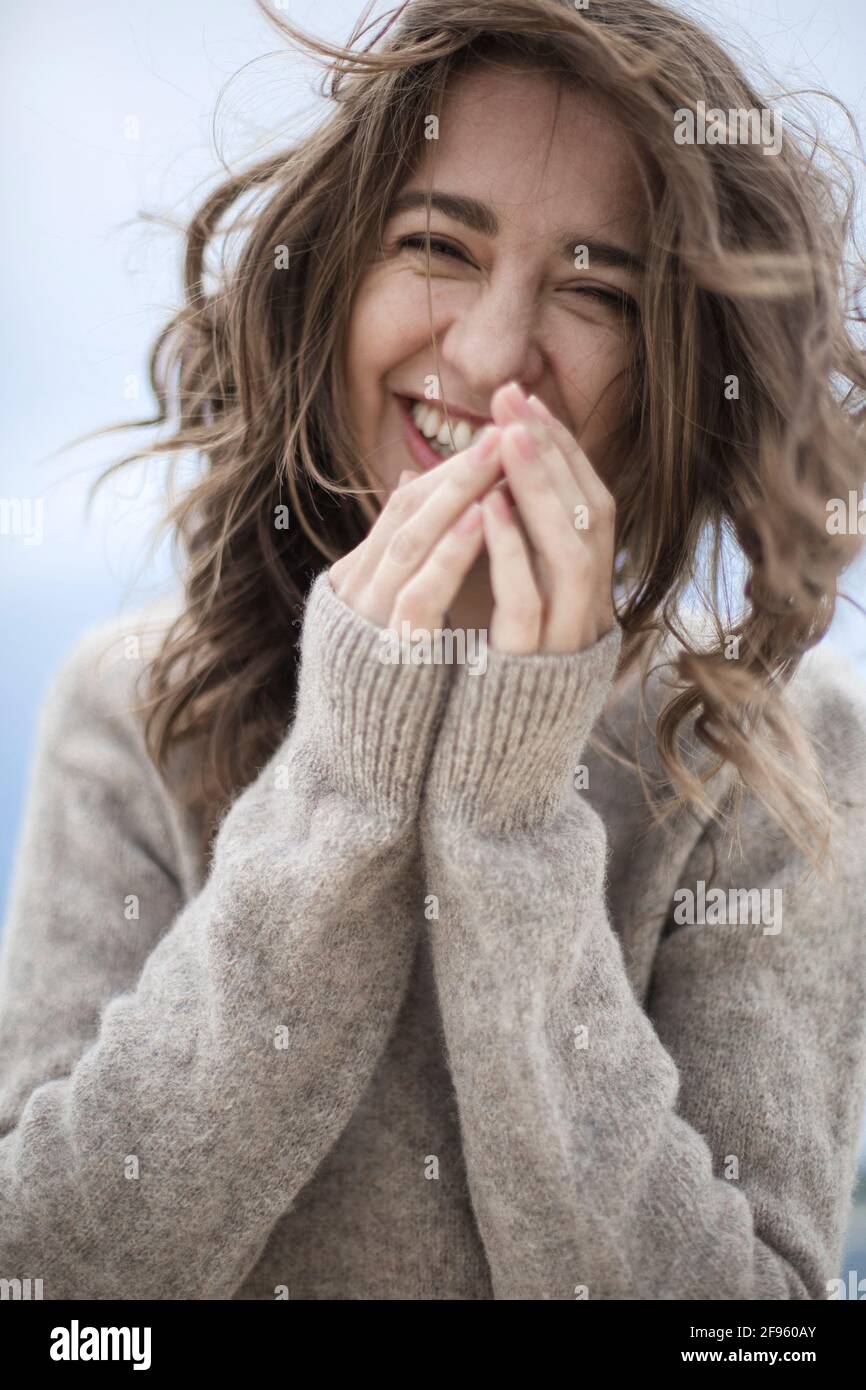 la chica ríe, el viento desarrolla el cabello de la chica, feliz, en un cálido Foto de stock