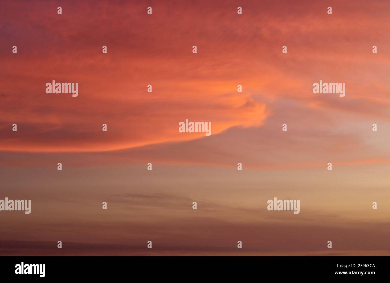 Romántico disparo escénico contra el cielo con las nubes en la puesta de sol Foto de stock