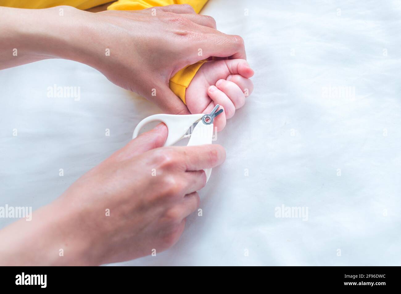 La Madre Corta Las Uñas Del Bebé Recién Nacido Con Tijeras De Uñas