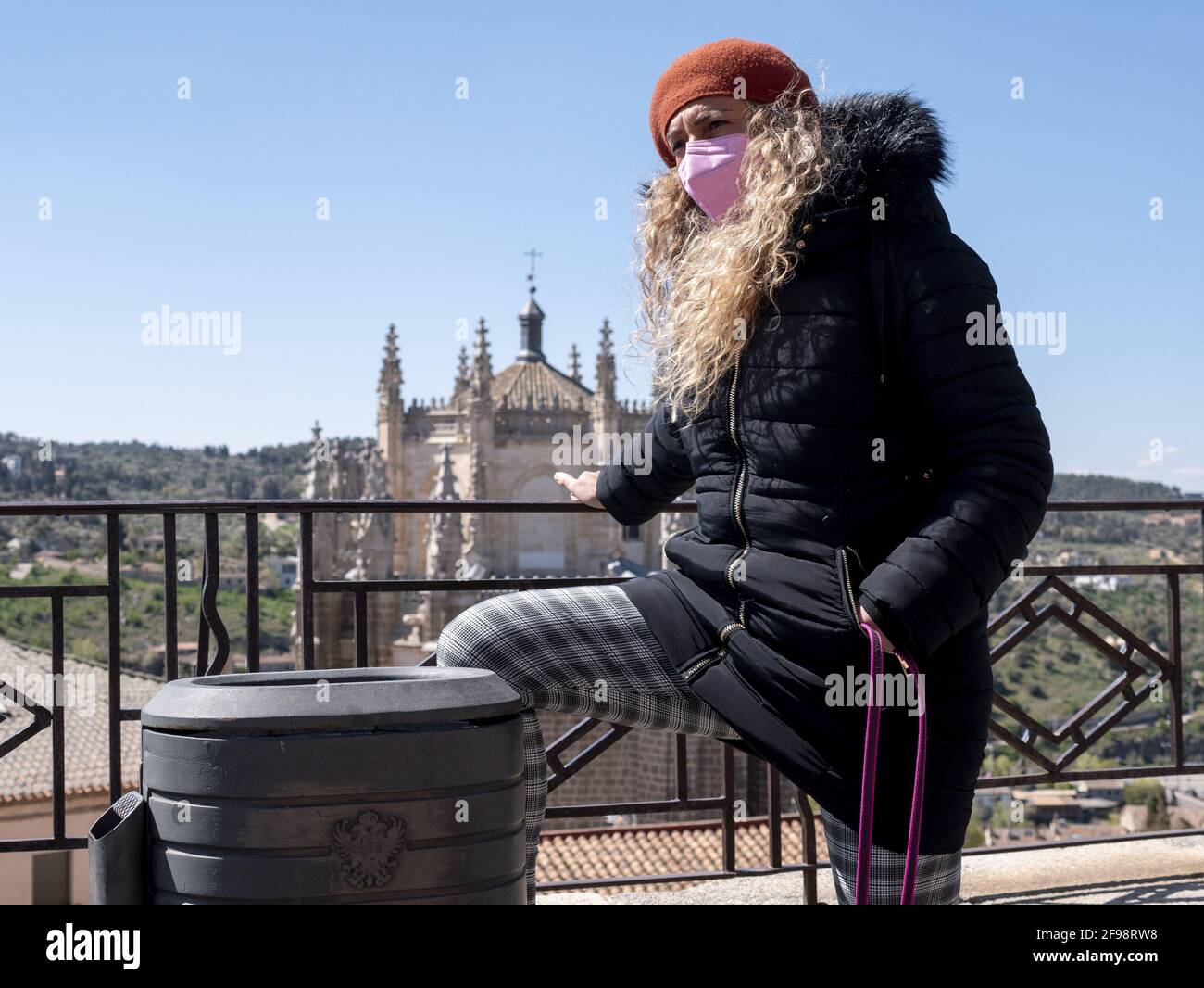 Atractiva mujer vestida con ropa de invierno y una máscara facial en las calles de Toledo, España Fotografía de stock - Alamy