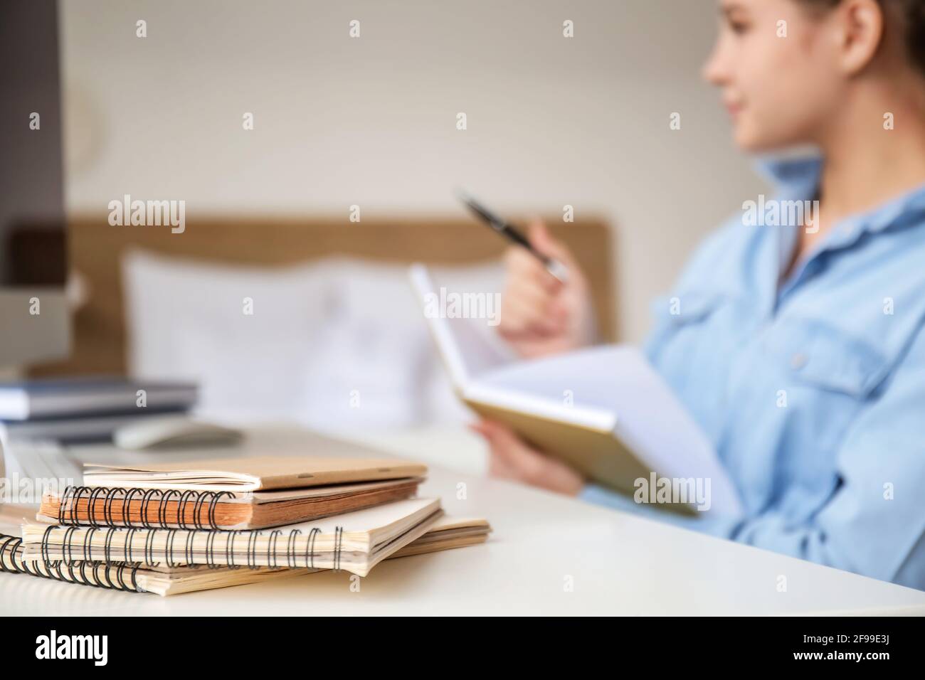Estudiante que estudia en línea en casa, foco en cuadernos Foto de stock