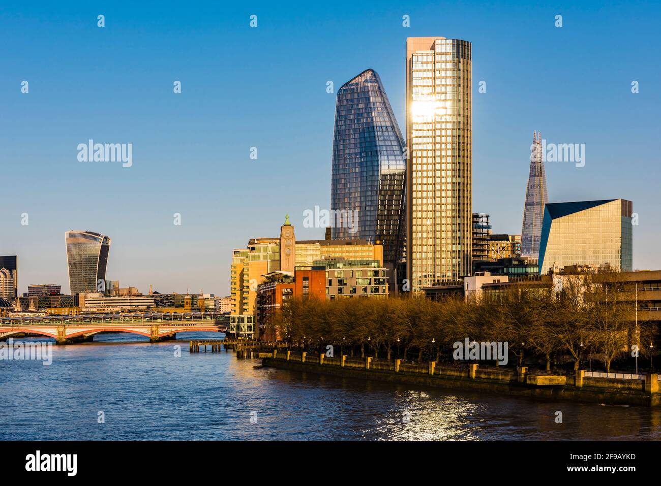 La puesta de sol se refleja en las ventanas del edificio con vistas al puente Blackfriars y al Támesis, Londres, Reino Unido Foto de stock