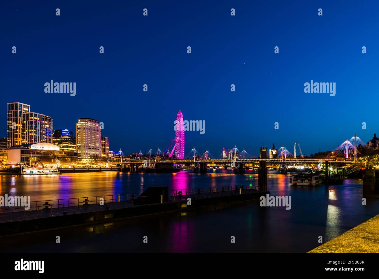 Luces en los puentes Hungerford y Golden Jubilee después del anochecer, Londres, Reino Unido Foto de stock
