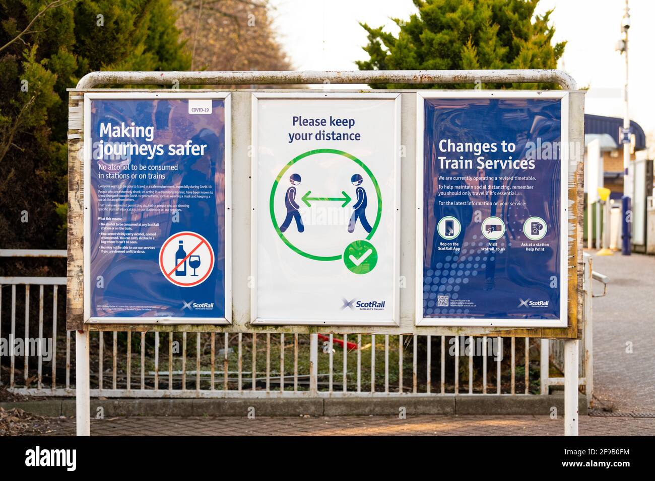 ScotRail por favor mantenga su distancia, sin alcohol y horario revisado carteles señales en la estación de tren de Balloch durante la pandemia de coronavirus, Escocia, Reino Unido Foto de stock