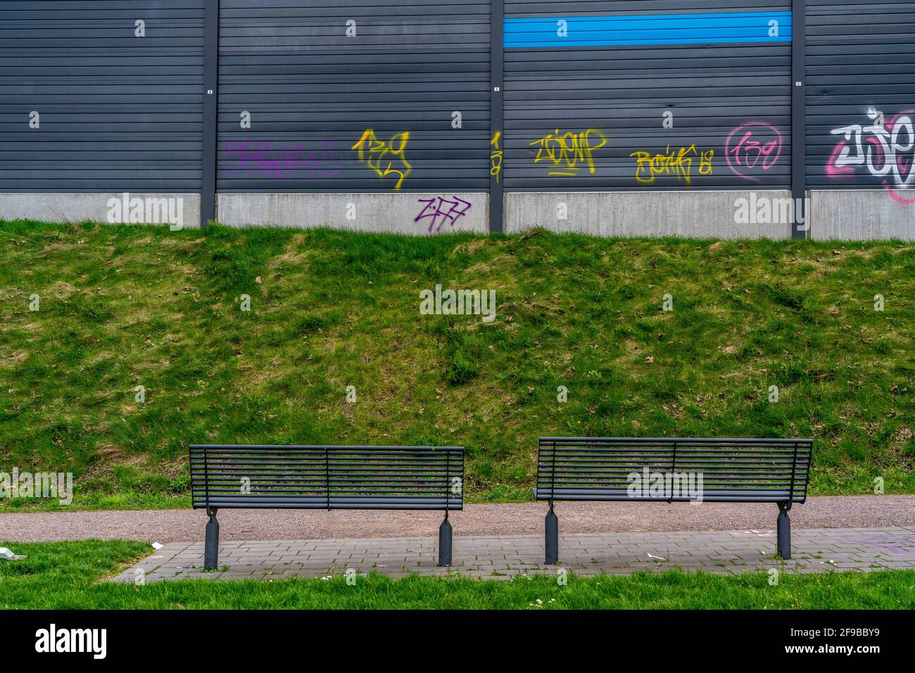 Espacio verde, en Duisburg-Beck, banco del parque con vista a la barrera del ruido de la autopista A42, Emscherschnellweg, NRW, Alemania Foto de stock