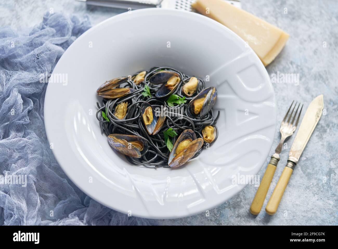 Pasta de espagueti de marisco negro con mejillones sobre fondo de piedra. Comida mediterránea deliciosa Foto de stock