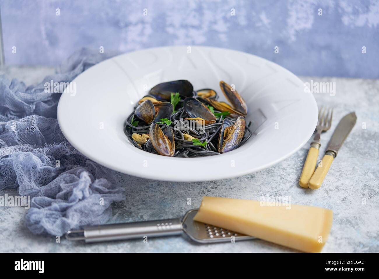 Pasta de espagueti de marisco negro con mejillones sobre fondo de piedra. Comida mediterránea deliciosa Foto de stock