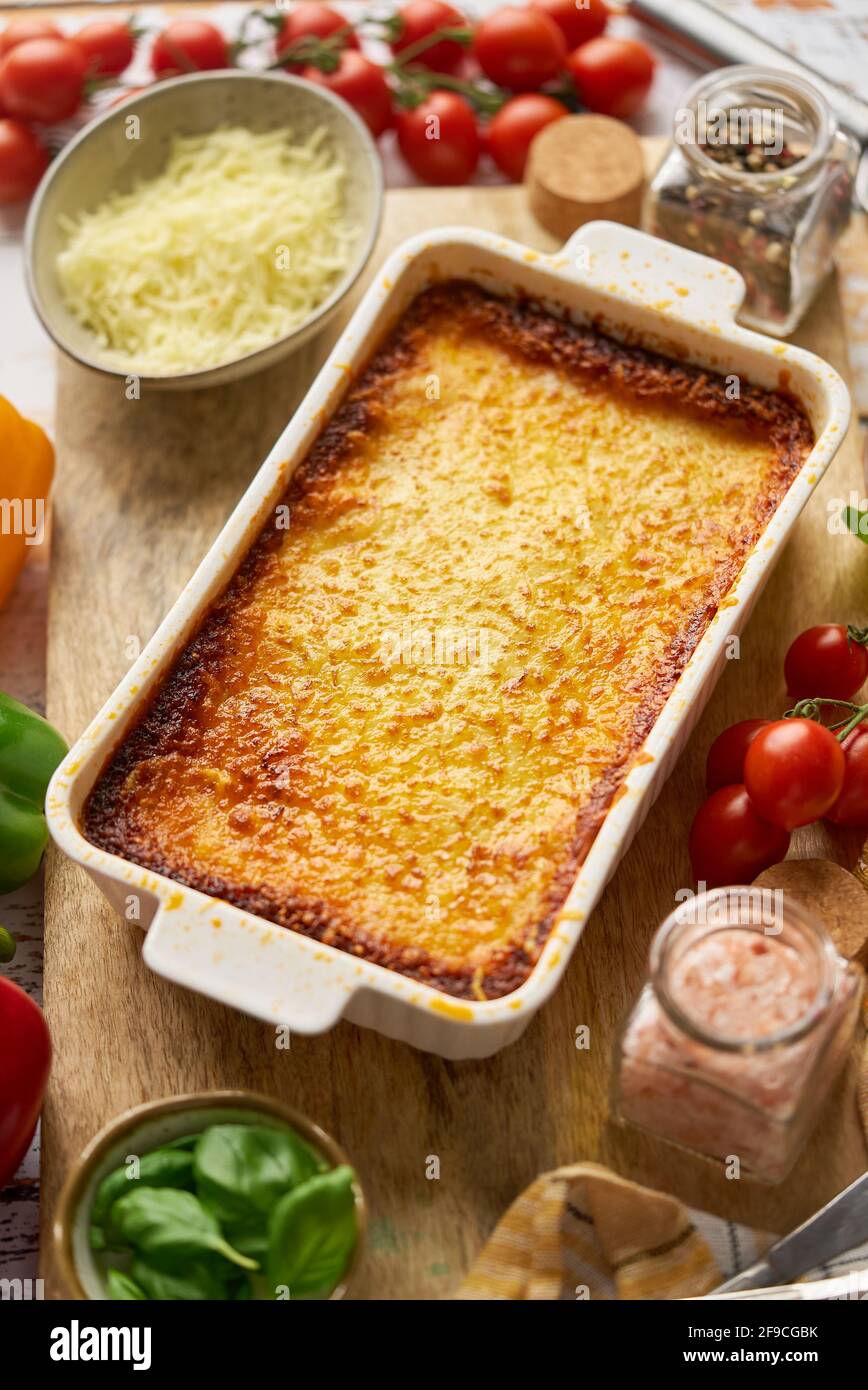 Sabrosa lasaña tradicional italiana con boloñesa, derretida y queso. Servido con ingredientes Foto de stock