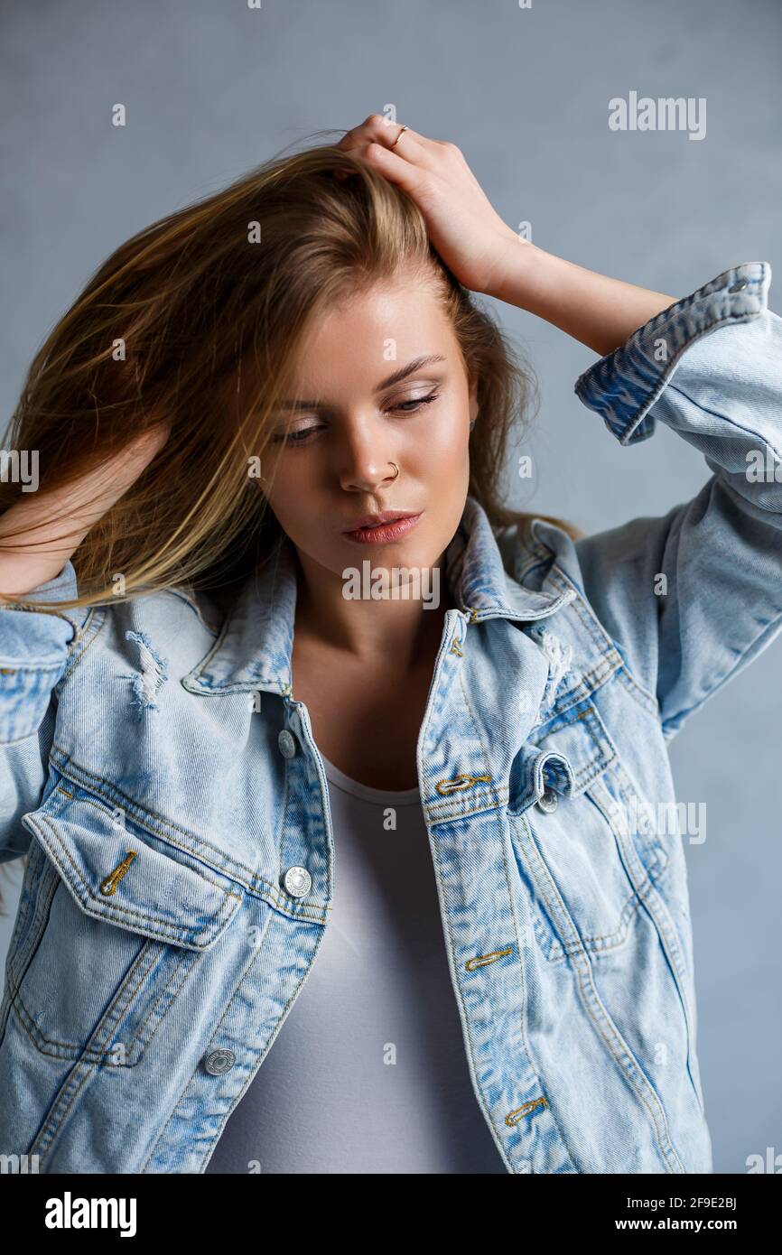 Retrato de una bella mujer joven vestida con jeans y top blanco