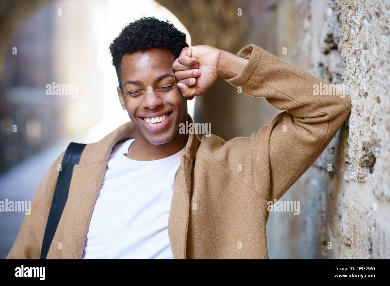 Feliz joven negro riendo en el fondo urbano. Foto de stock