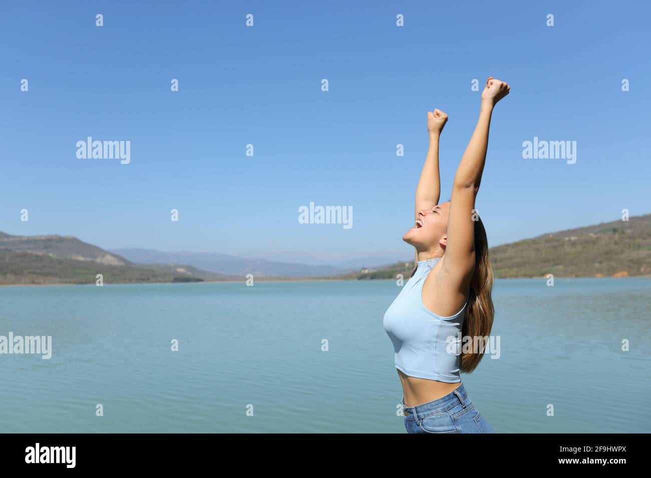Perfil de una mujer emocionado celebrando vacaciones en un lago Foto de stock