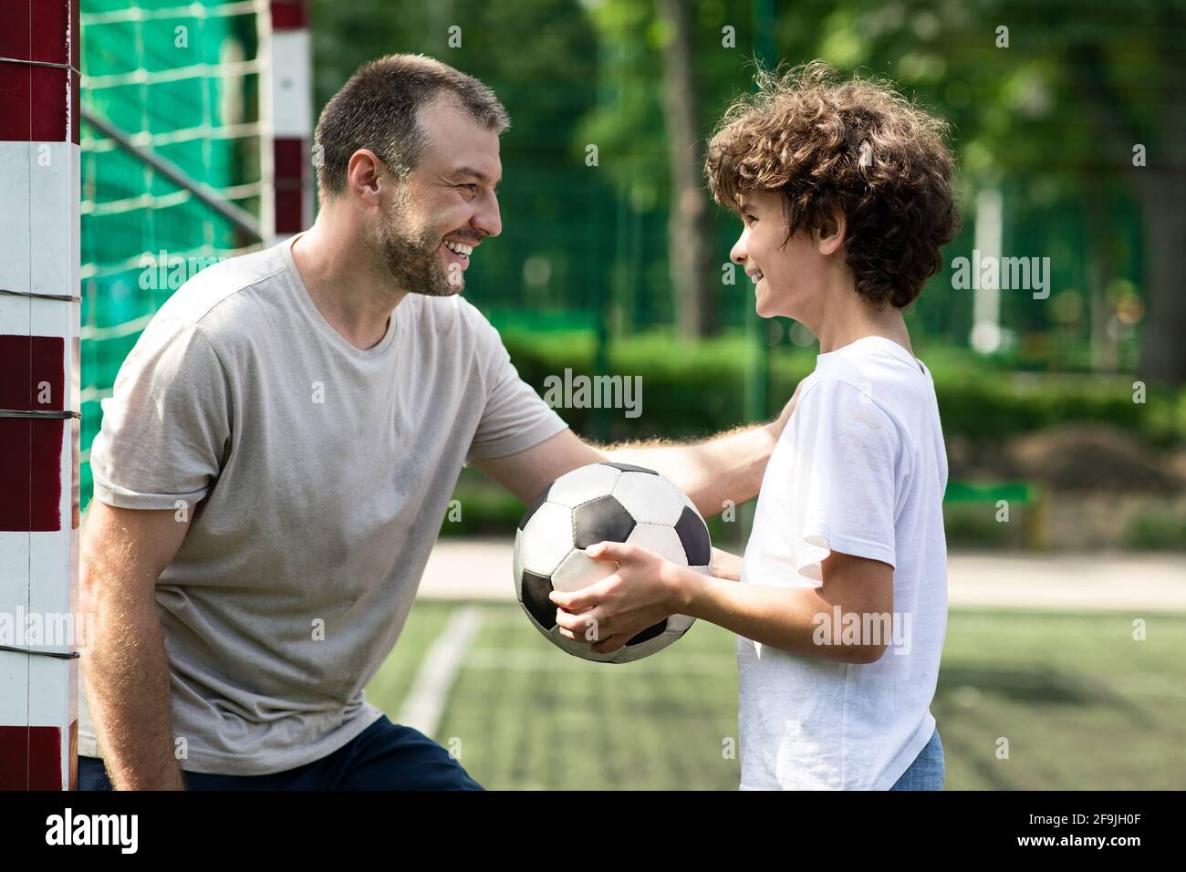 Papá adulto deportivo jugando fútbol con su hijo Foto de stock