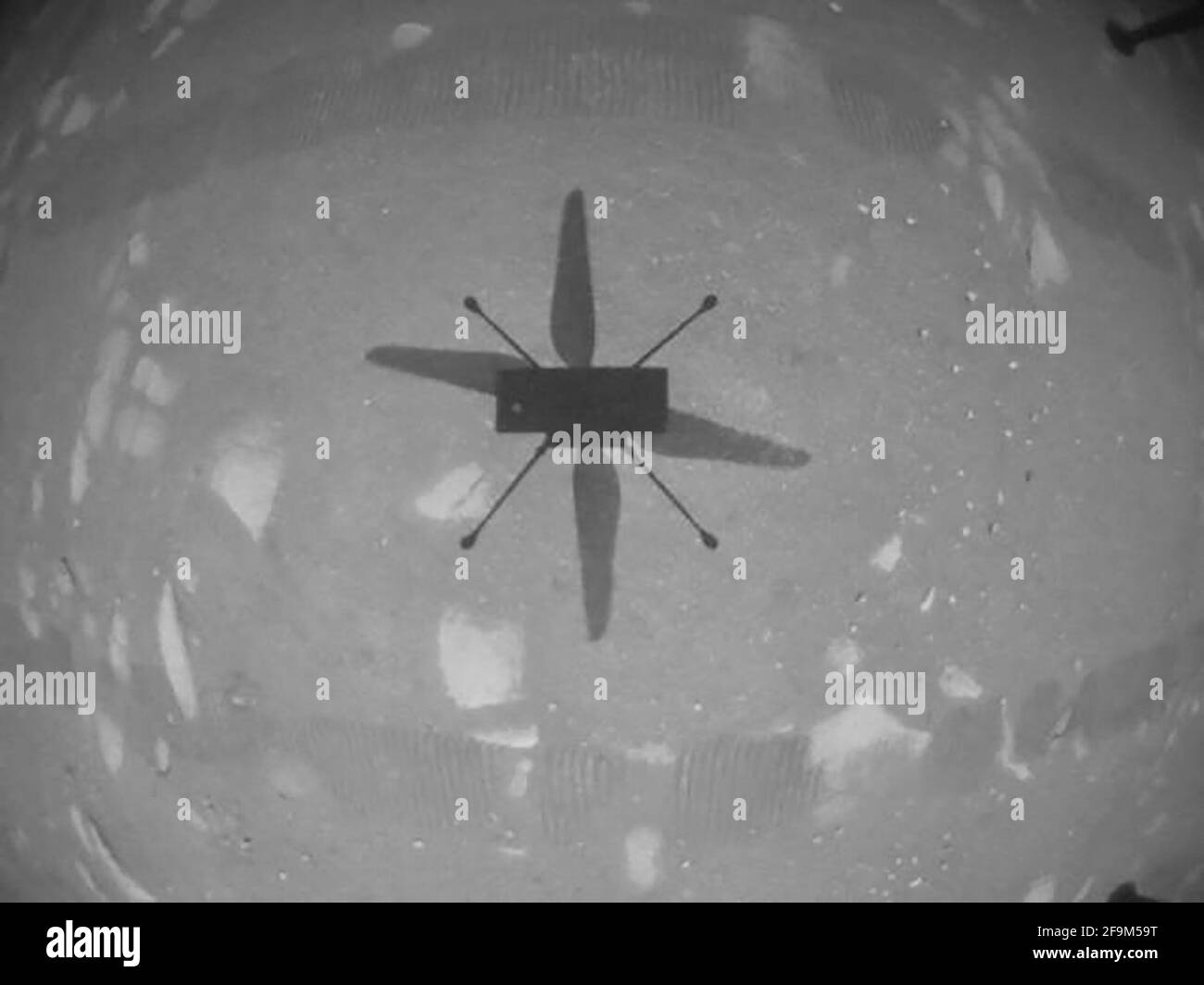 El helicóptero Ingenuity Mars de la NASA capturó este disparo mientras volaba sobre la superficie marciana el 19 de abril de 2021, durante la primera instancia de vuelo controlado y motorizado en otro planeta. Utilizó su cámara de navegación, que sigue el terreno de forma autónoma durante el vuelo. Foto del folleto por JPL-Caltech/NASA viaABACAPRESS.COM Crédito: Abaca Press/Alamy Live News Foto de stock
