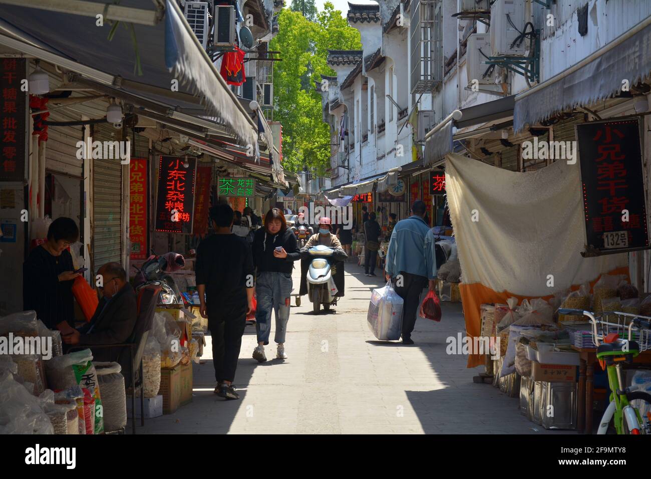 Todos los días se acerca en una pequeña comunidad de China. La gente que va sobre su negocio en las calles estrechas de este área del centro. Foto de stock