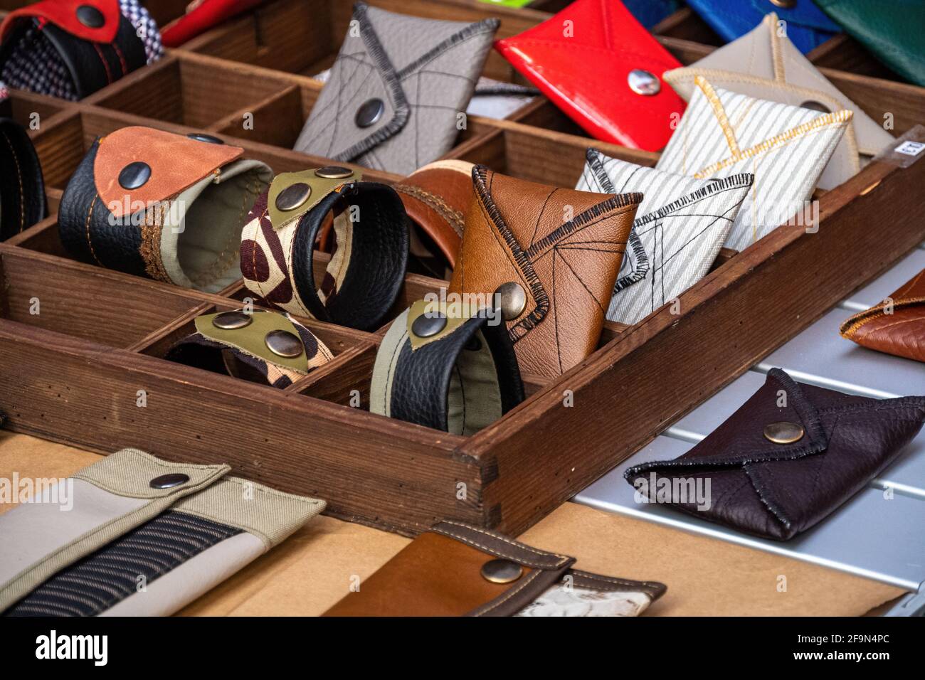 Carteras y pulseras hechas a mano, de cuero tela, con remaches en un estante de la Accesorio de moda Fotografía de stock -