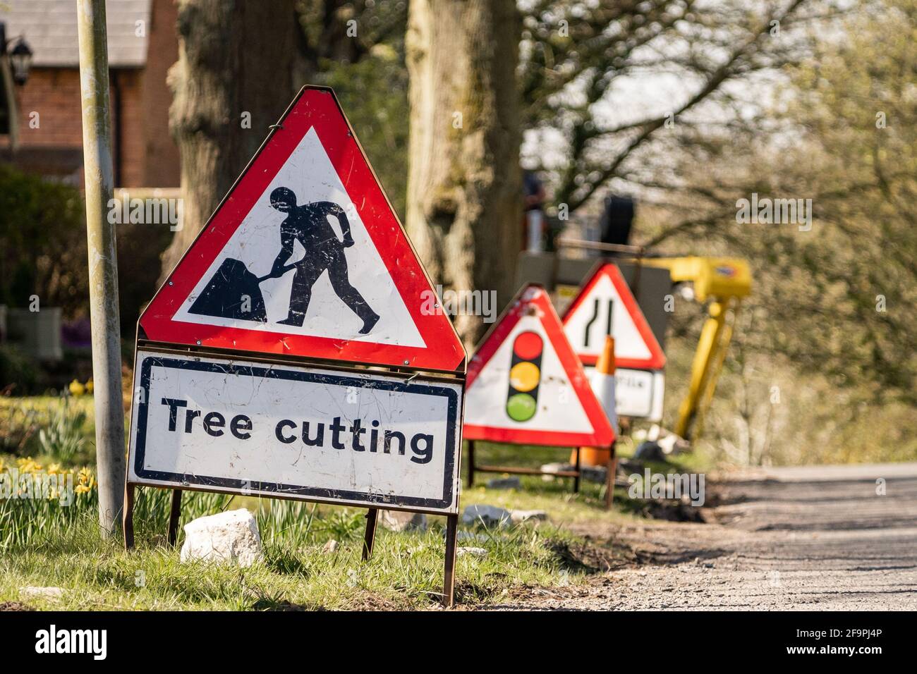 Señal de advertencia de corte de árboles roja y blanca al lado de la  carretera con el símbolo de trabajador de obras de carretera. Señales de  tráfico que alertan a los conductores