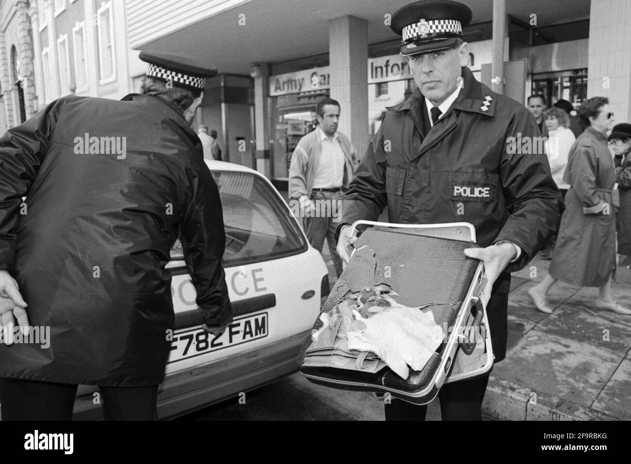 La policía retira un maletín sospechoso que se dejó fuera de las oficinas de reclutamiento del Ejército en Salisbury en 1990. La policía siempre estaba alerta por paquetes sospechosos, ya que el IRA todavía estaba realizando una campaña de bombardeo en el continente en 1990s. Foto de stock