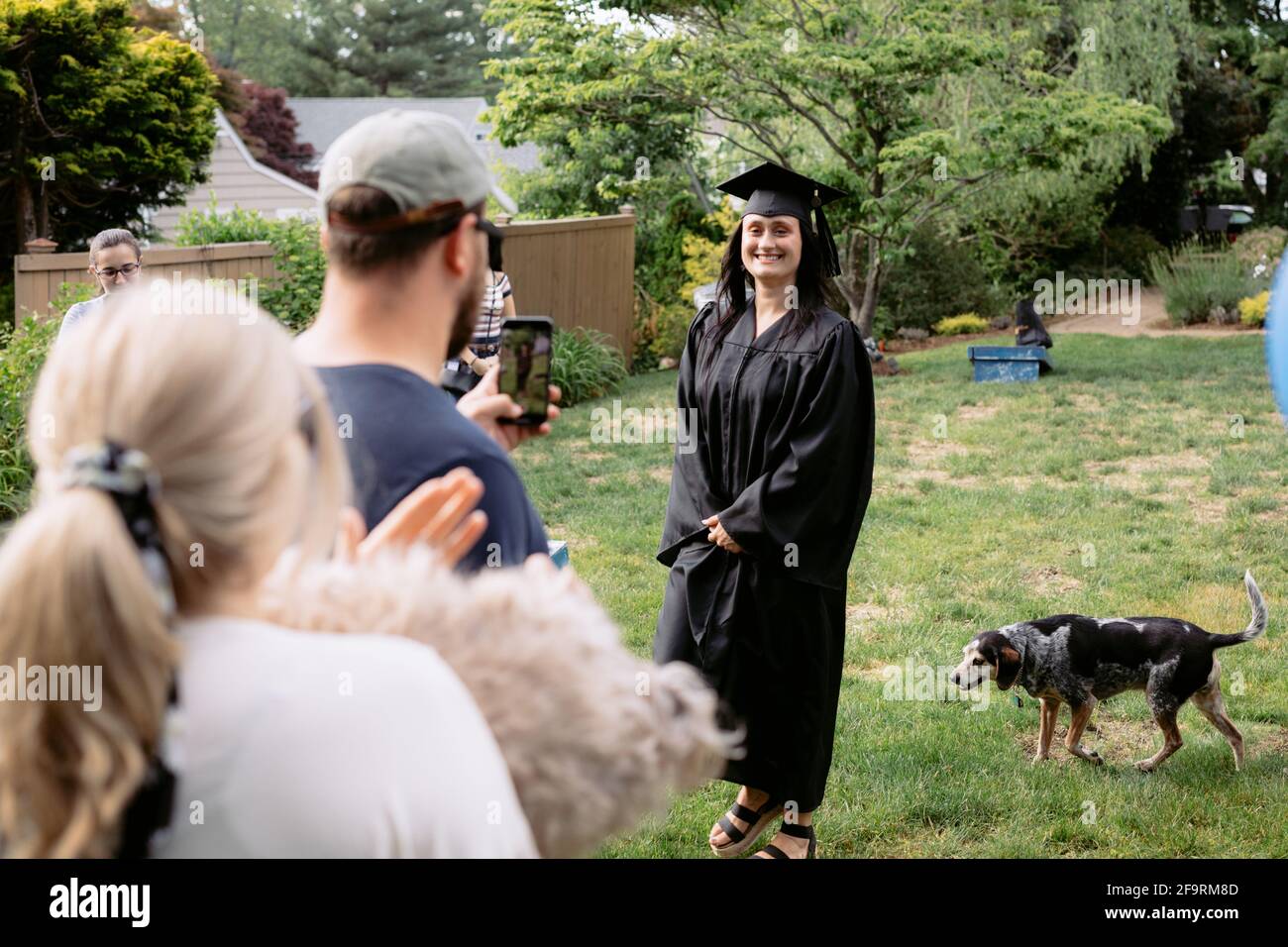 La mujer joven procesando en ceremonia de graduación del patio trasero Foto de stock