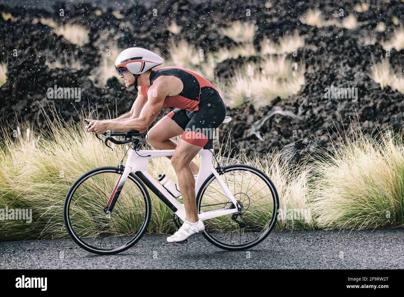 Bicicleta triatleta hombre ciclismo bicicleta carretera bajo la lluvia  durante la carrera de triatlón en el paisaje natural de Hawai. Deporte  atleta entrenamiento entrenamiento resistencia Fotografía de stock - Alamy